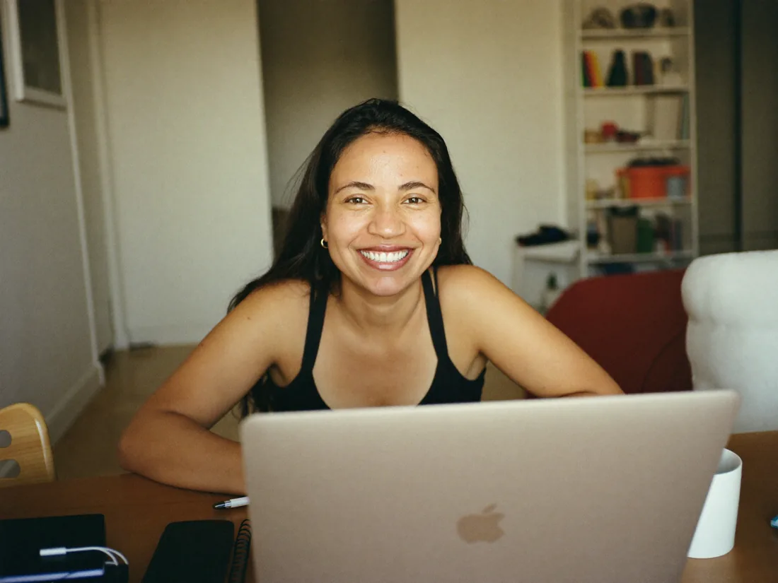 Mujer sonriente frente a su computador portátil