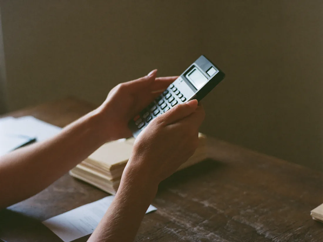 Manos con una calculadora y papeles