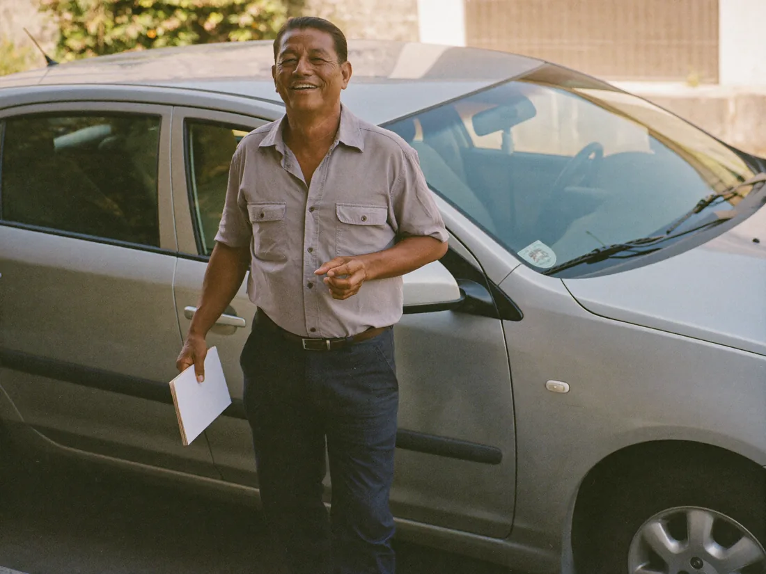Conductor junto a su carro con un documento