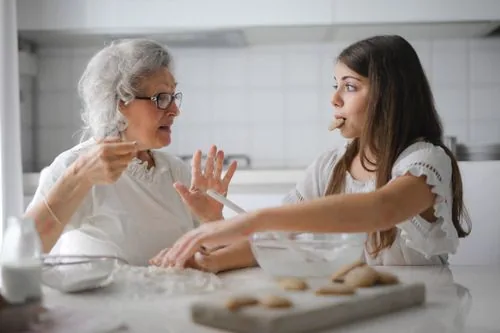Imagen ilustrativa. Abuela y nieta preparan galletas en la cocina.